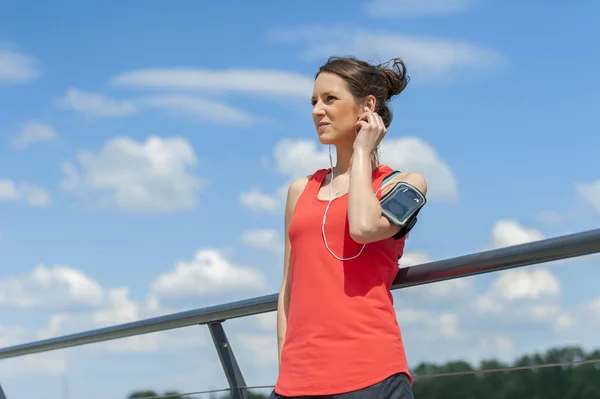 Fit descanso de la mujer después de correr y escuchar música . — Foto de Stock