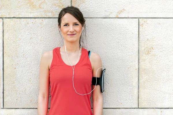 Fit descanso de la mujer después de correr y escuchar música . — Foto de Stock