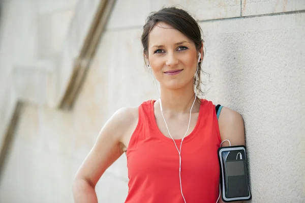 Fit descanso de la mujer después de correr y escuchar música . — Foto de Stock