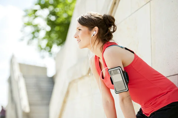 Fit femme repos après le jogging et écouter de la musique . — Photo