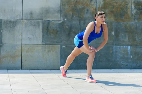 Fitness žena roztáhnout cvičení před montáží. — Stock fotografie