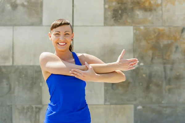 Fitness žena roztáhnout cvičení před montáží. — Stock fotografie