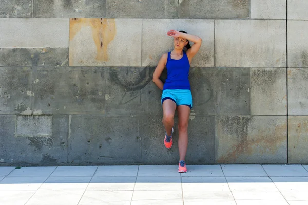 Mulher descansando depois de correr pela parede. Ao ar livre . — Fotografia de Stock