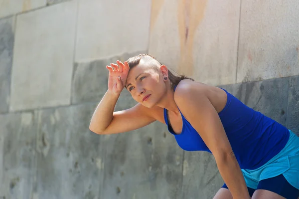 Femme se reposant après avoir couru près du mur. Extérieur . — Photo