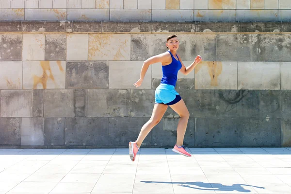 Jogger mulher saltar pela parede na cidade . — Fotografia de Stock