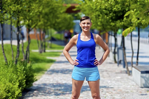 Mujer jogger en parque sonriendo . —  Fotos de Stock