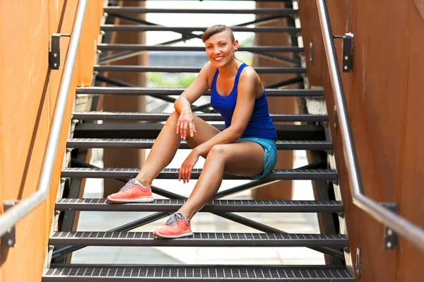 Apto mulher descansando depois de correr em escadas sorrindo . — Fotografia de Stock