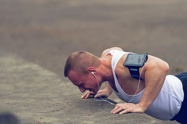 Hombre activo haciendo flexiones al aire libre . — Foto de Stock