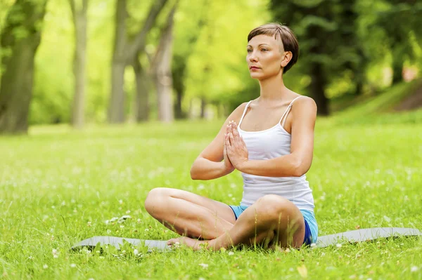 Vrouw doet yoga op de medow. — Stockfoto