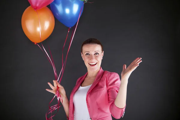 Frau mit Luftballons auf weißem Hintergrund lächelt — Stockfoto