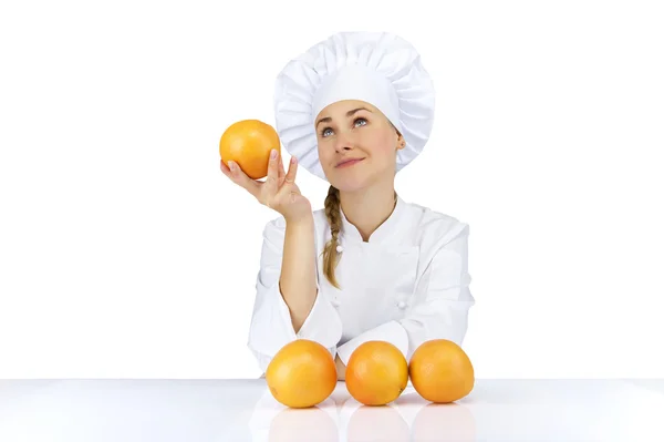 Femme chef en uniforme. Isolé sur fond blanc avec des oranges — Photo