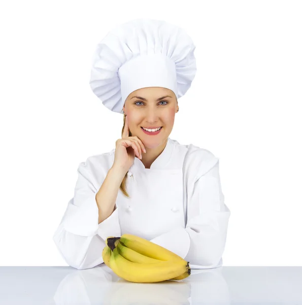 Vrouw chef-kok in uniform. Geïsoleerd op een witte achtergrond met bananen — Stockfoto