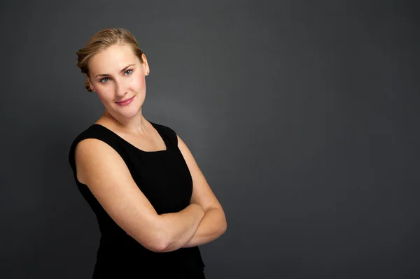 Portrait of a beautiful young business woman standing against gr — Stock Photo, Image