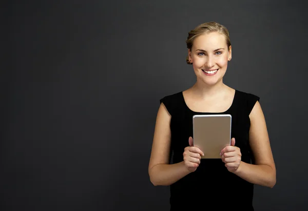 Giovane donna utilizzando un tablet su sfondo scuro — Foto Stock