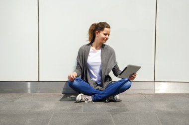 Genç Ipad göz cam duvar tarafından süre gülüyor