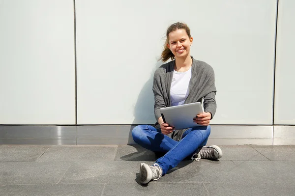 Teenager lachen beim Anblick des iPads an der Glaswand — Stockfoto