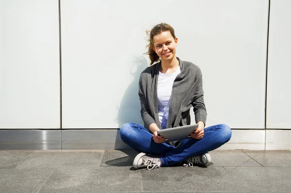 Teenager lachen beim Anblick des iPads an der Glaswand — Stockfoto