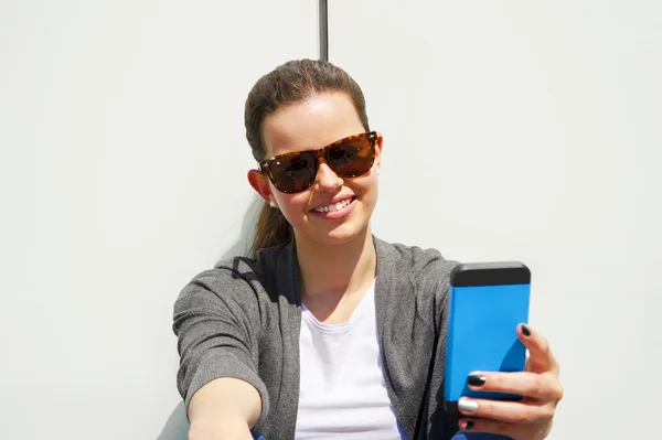 Гарненька молода жінка використовує мобільний телефон — стокове фото