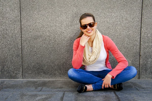 Felice giovane donna sta sorridendo con un muro vuoto fuori con cantato — Foto Stock