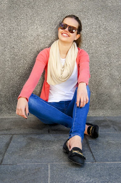 Girl by the wall in city smiling — Stock Photo, Image