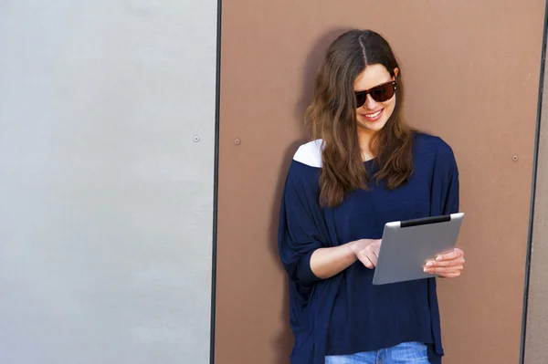 Ung kvinne bruker en digital nettbrett-datamaskin med stort smil – stockfoto