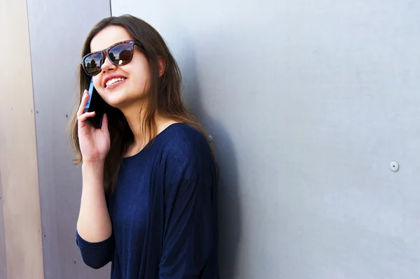 Femme gaie parlant au téléphone dans la rue tenue décontractée — Photo