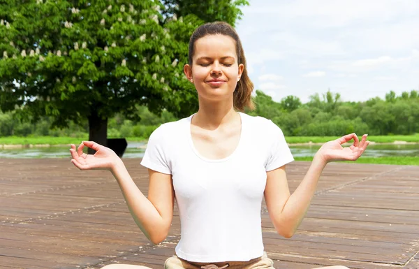 Ung flicka gör yoga i parken — Stockfoto