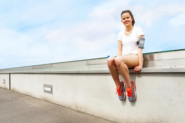 Giovane ragazza che riposa vicino al muro. Vestito da joging . — Foto Stock