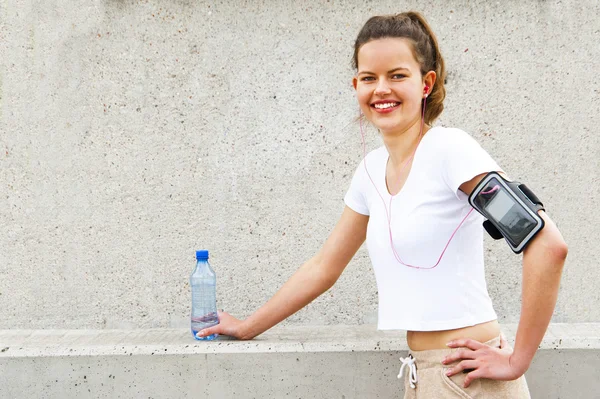 Junge Frau ruht sich nach Lauf mit Wasser aus. — Stockfoto