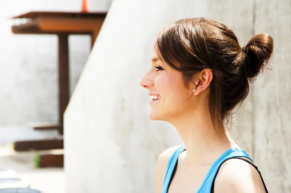 Joven mujer descansando después de correr por la pared en la ciudad con una gran sonrisa — Foto de Stock