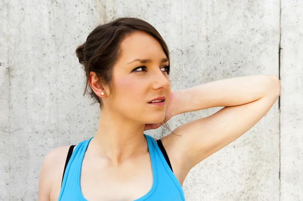 Young woman stretching after run by the wall in city with big sm — Stock Photo, Image