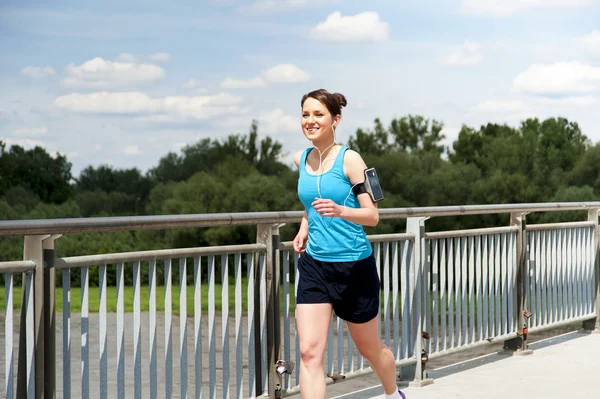 Chica joven corriendo en teh ciudad, sobre el río por el puente —  Fotos de Stock