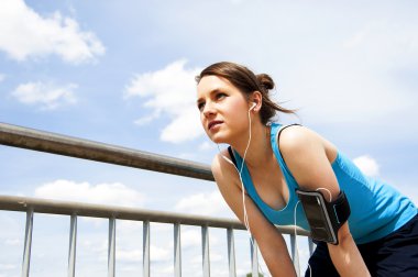 genç kadın çalıştırdıktan sonra dinlenme. Mavi spor içinde. üzerinde gökyüzü