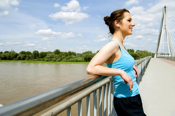 Young moe vrouw rest nadat lopen in de stad over de brug. — Stockfoto