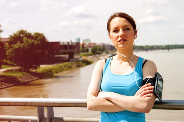 Müde junge Frau rastet nach Lauf über Brücke in der Stadt aus. — Stockfoto