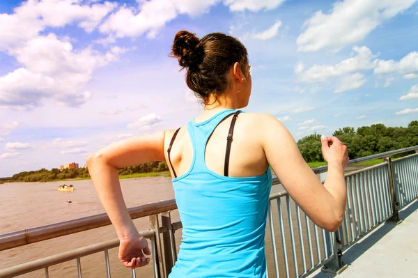 Muchacha joven corriendo en thr ciudad, sobre el río por el puente, ba —  Fotos de Stock