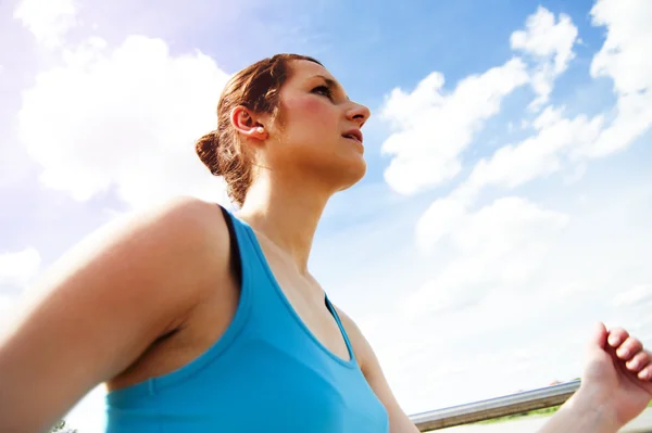 Giovane donna che corre in città oltre il ponte alla luce del sole . Foto Stock