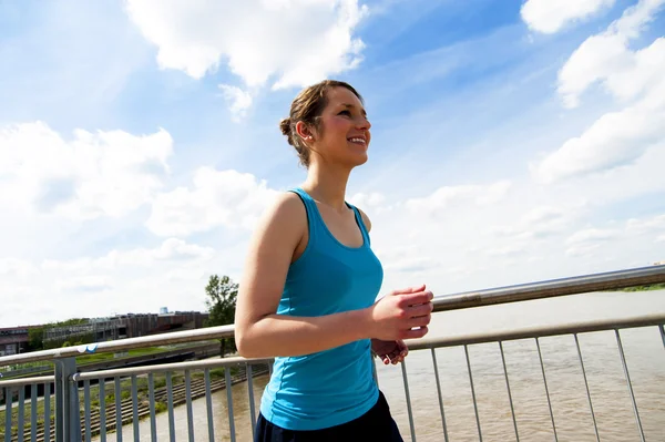 Young woman runing in the city over the brige in sun light. — Stock Photo, Image