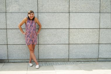 Genç modern kadın için camer gülümseyen City duvara