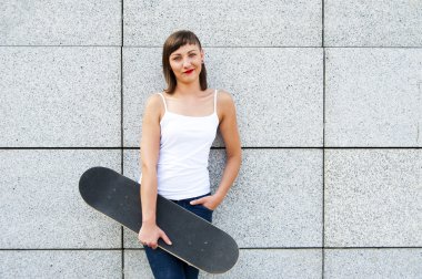 Duvar gülümseyen tarafından şehrin kaykay ile genç kız.