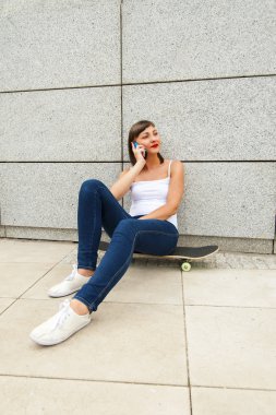 Genç kız tarafından konuşmayı City'deki kaykay üzerinde siting nea telefon