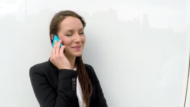 Mujer de negocios hablando por teléfono contra la pared de cristal — Vídeo de stock