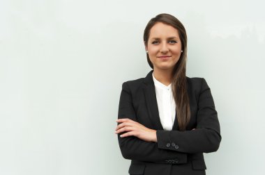 İş kadını kameraya gülümseyen City cam duvar tarafından.