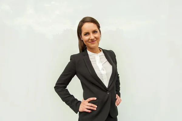 Ung kvinna i business outfit under glasväggen i staden s — Stockfoto