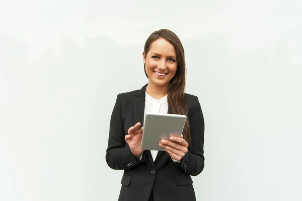 Jovem empresária tocando tablet pela parede da cidade . — Fotografia de Stock