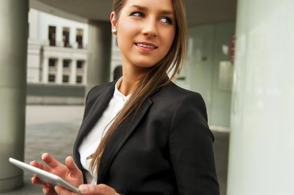 Jeune femme d'affaires touchant tablette près du mur dans la ville . — Photo