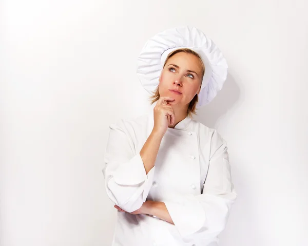 Mulher chef olhar para cima e pensar com o dedo perto do rosto, mais — Fotografia de Stock