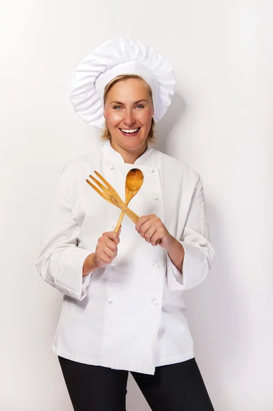 Woman chef with spoon and fork crossed over white background smi — Stock Photo, Image