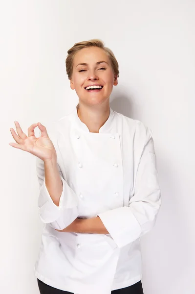 Kvinnelig kokk med skilt, perfekt hånd, over hvem-bakgrunn-smil – stockfoto