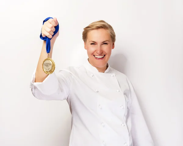 Kvinna i kocken outfit och första pris medalj leende. — Stockfoto